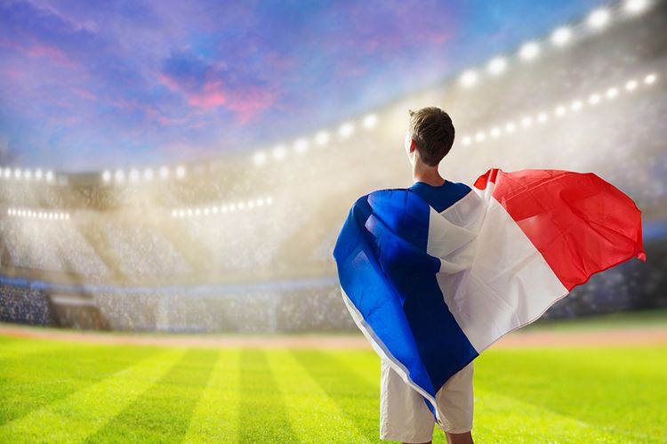 Man on Football Pitch Holding French Flag