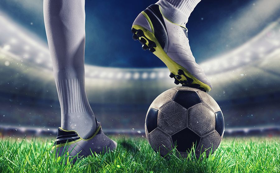 Footballer with White Boots and Socks Standing on Ball